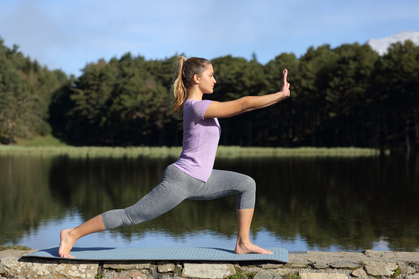 Woman practicing tai chi pose in a lake