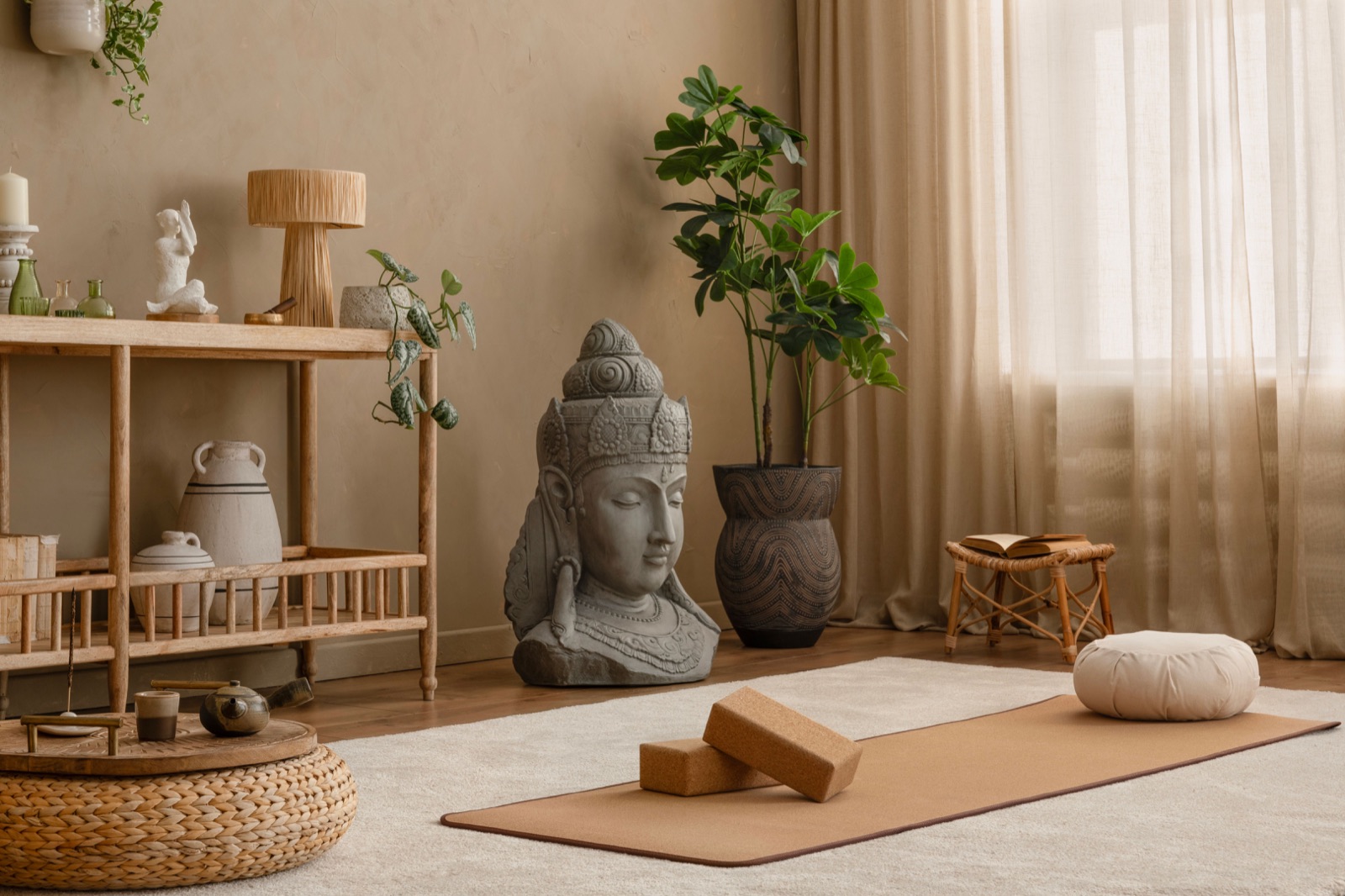 Cozy meditation setup with a woven pouf, yoga mat, and incense burner. A serene Buddha statue and natural accents complete the calming atmosphere.